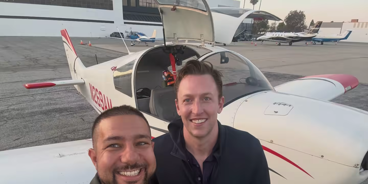 Hitch and Robbie smiling in front of a training aircraft after Hitch earned his instrument rating